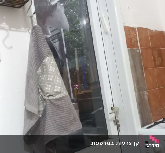 מדף עם תבלינים ליד חלון זכוכית